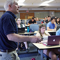 man in front of classroom teaching students