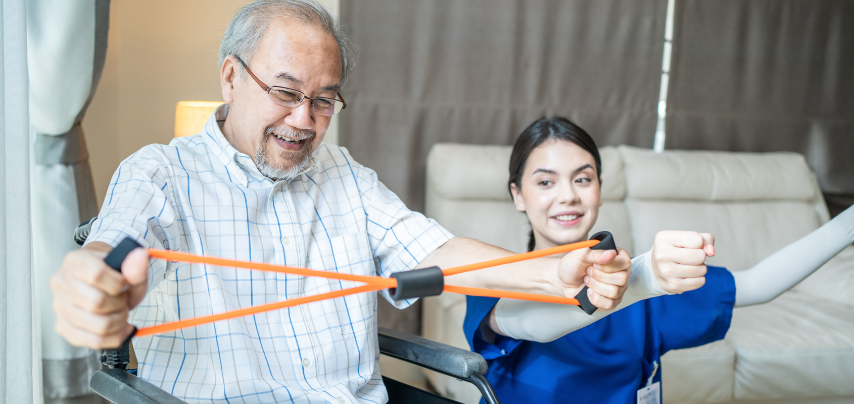 woman coaches elderly man through resistance band exercises