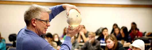 professor teaching class, holding skull