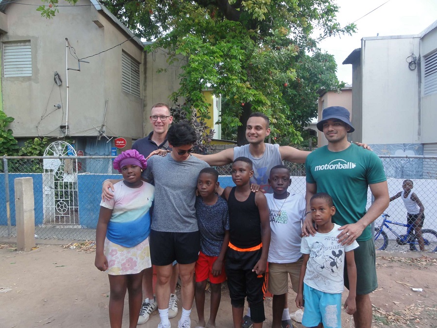 Shareer Farooq (right) poses for photo with Jamaican children, KPE classmates and Professor Simon Darnell